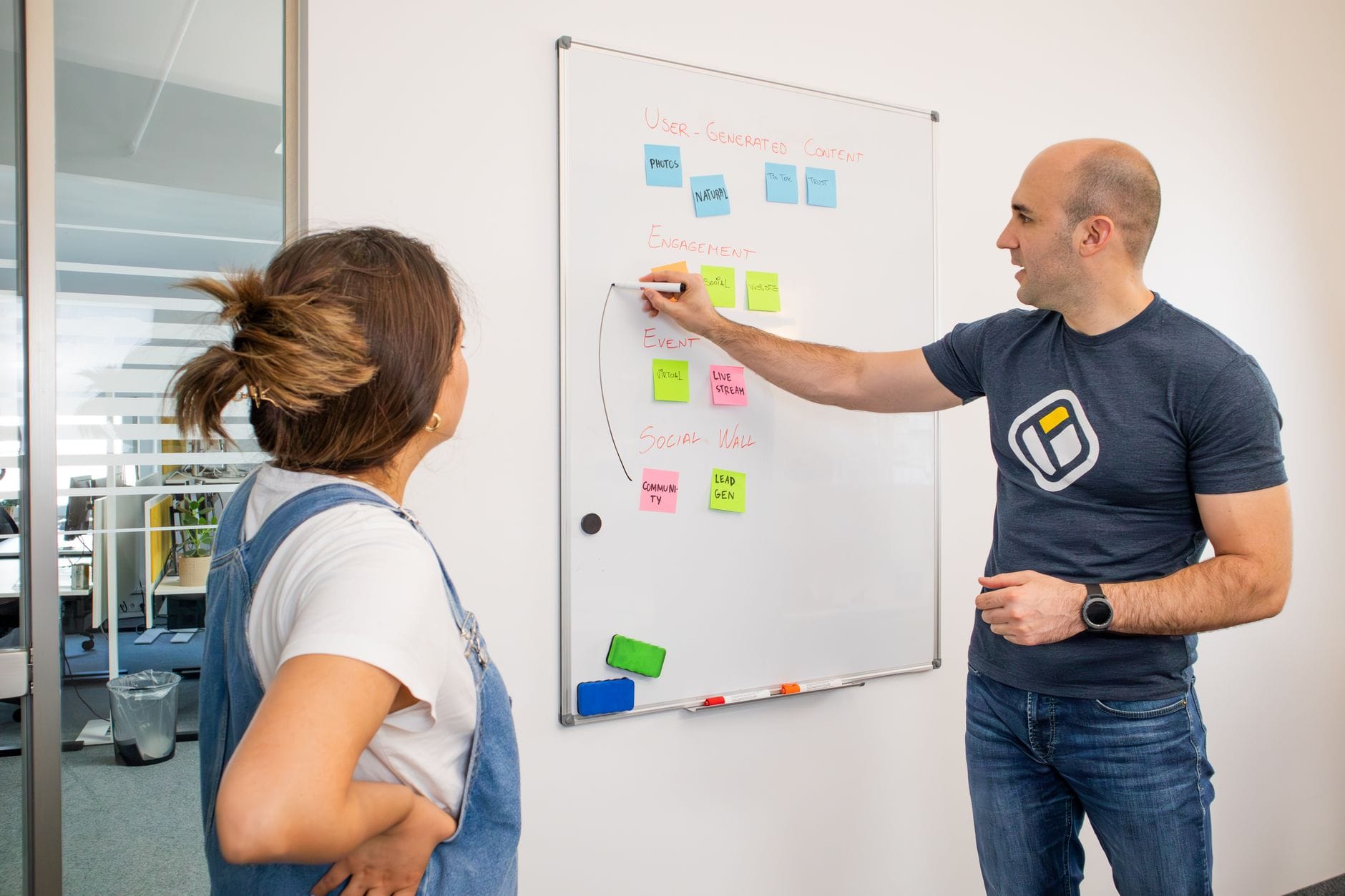 Kubernetes w małej firmie czy to ma sens i jak uprościć procesy wdrożeniowe Dwóch współpracowników omawia strategię na tablicy w biurze IT