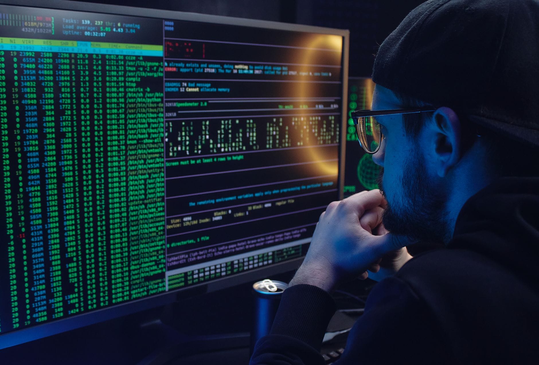 Skrypty Bash vs PowerShell vs Python: co lepiej sprawdzi się w codziennej administracji Programista pracujący przy dwóch monitorach z kodem w ciemnym biurze