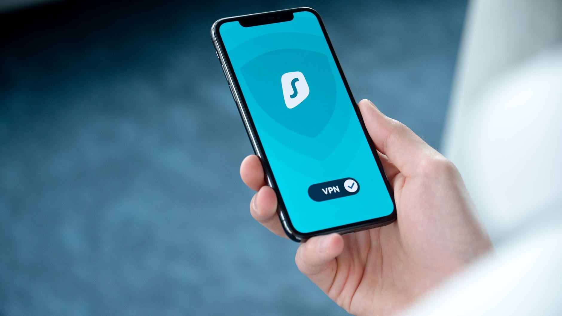 VPN na smartfonie: konfiguracja Android i iOS, bezpieczeństwo aplikacji oraz pułapki darmowych usług na telefonie Dłoń trzyma smartfon z włączoną aplikacją VPN do bezpiecznego przeglądania