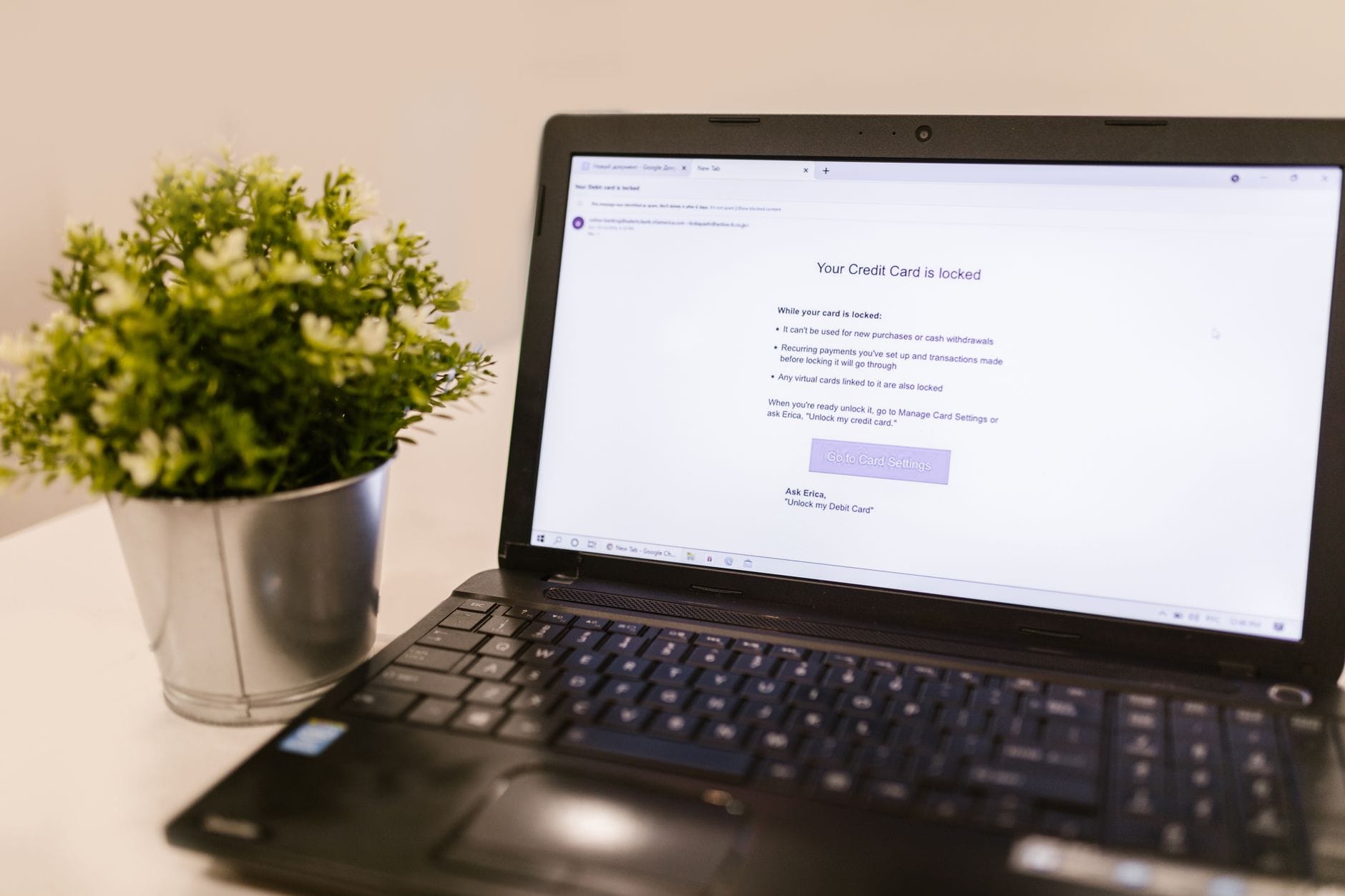 Nowe funkcje bezpieczeństwa w Gmail i Outlook: co warto włączyć od razu Ekran laptopa z alertem bezpieczeństwa karty kredytowej obok rośliny