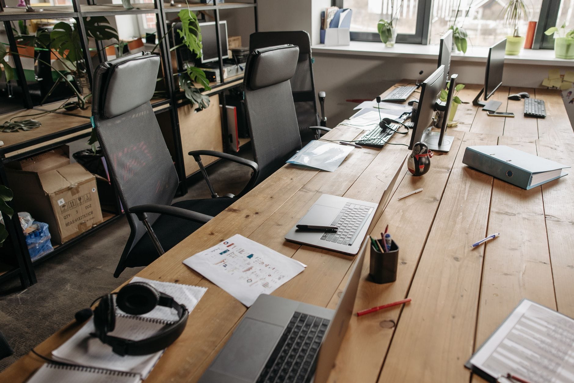 Przestrzeń coworkingowa z drewnianymi biurkami i laptopami