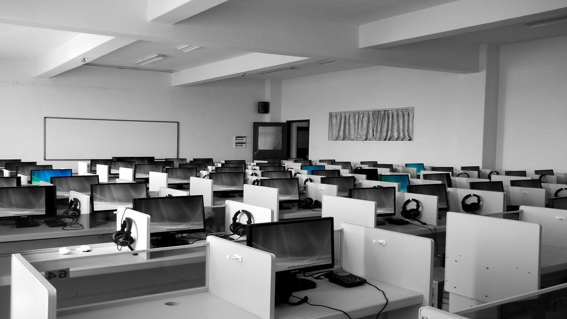 Porządkowanie Windows 11: jak przyspieszyć system bez reinstalacji Puste biuro typu call center z rzędami biurek i komputerów